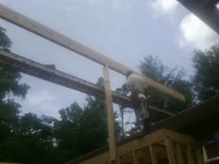 Carpenter setting a ridge beam over a new addition frame — Ice Dam Removal by Roofing Brothers in Mc Cracken
