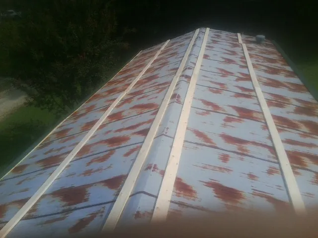 Rusted metal roof panels with new wood purlins before replacement — Storm Damage Roof Repair in Mc Cracken by Roofing Brothers