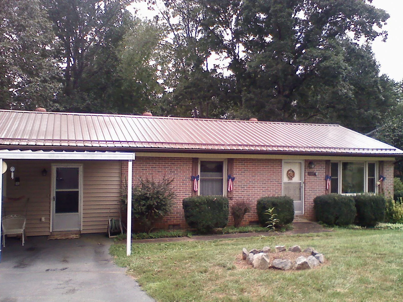 Bronze metal roof and carport on a brick ranch home — Roof Repair work by our crew in Mc Cracken