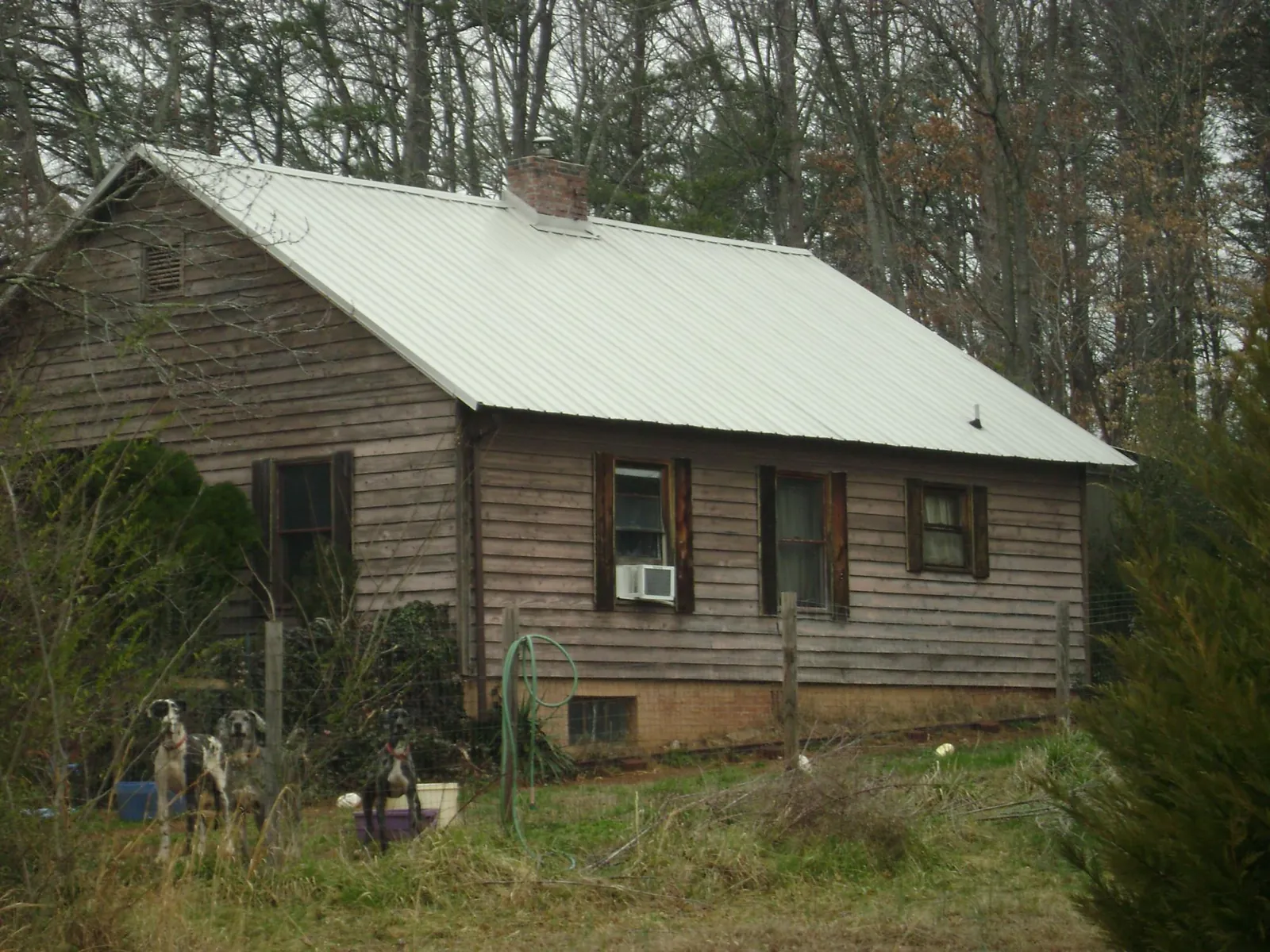 White metal roof on an old wood sided farmhouse, from a Metal Roof Installation job in Mc Cracken